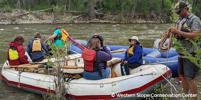 kids riding raft exploring river