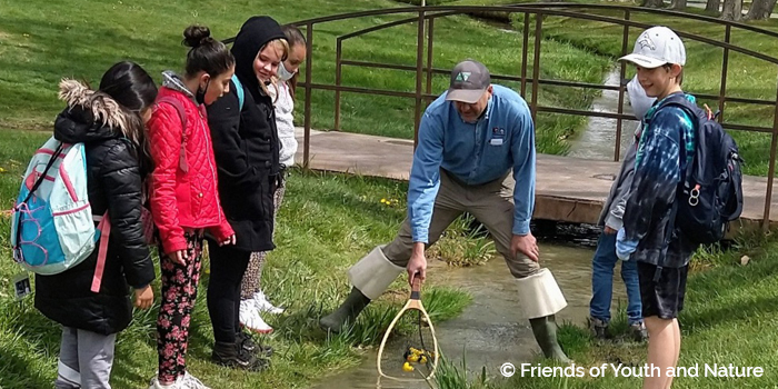 kids learning along stream